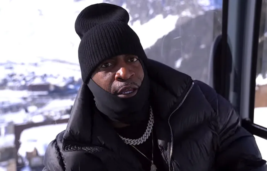 Tony Yayo stojący w śnieżnym krajobrazie szwajcarskich Alp, ubrany w zimową odzież, na planie teledysku do utworu John Wick