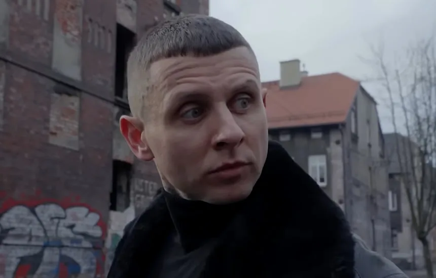 Kadr z teledysku W moich butach 4 przedstawiający twarz KaeNa w klimatycznym, surowym ujęciu. Artysta ukazany w emocjonalnym momencie, oddającym głębię przekazu utworu.