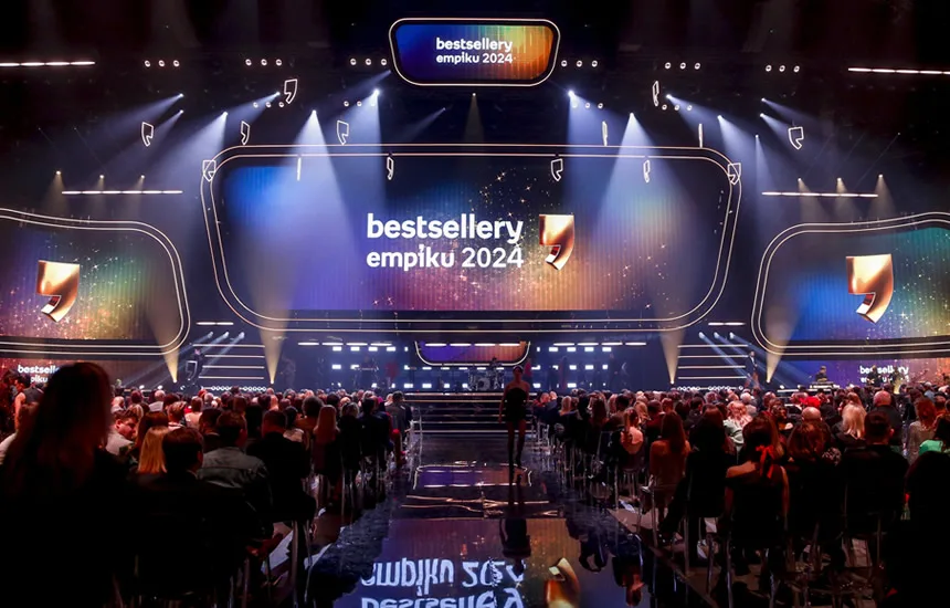 Scena gali Bestsellery Empiku 2024 z efektownym oświetleniem i dynamiczną grą świateł. Widownia wypełniona gośćmi, którzy z zainteresowaniem obserwują występy i przemówienia laureatów.