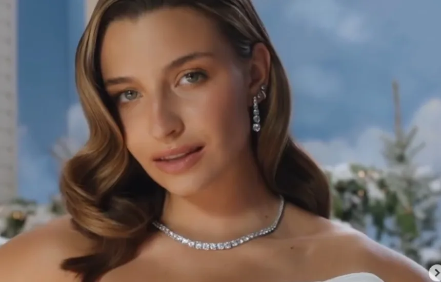 Julia Wieniawa w świątecznej stylizacji podczas nagrania do kampanii, śpiewa refren piosenki Last Christmas