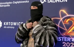 Raper w futrzanej kurtce i kominiarce na ściance Sylwestra z Dwójką 2025 w Katowicach