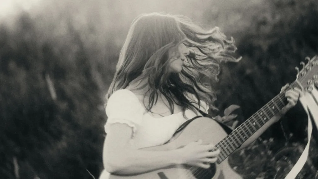 Aga Laura grająca na gitarze w plenerze - kadr promujący singiel Zwiedzam Świat