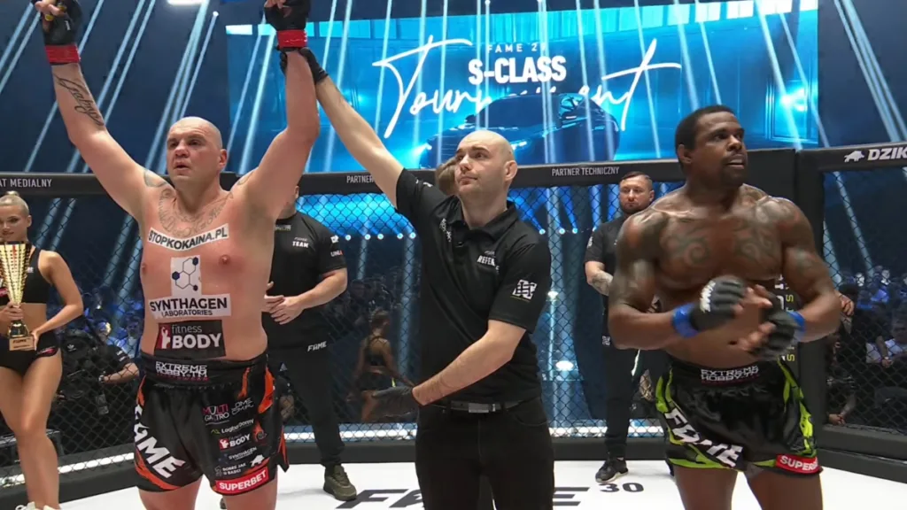 Zawodnik podnosi ręce w geście zwycięstwa po wygranej przez TKO w ćwierćfinale turnieju FAME 29 w klatce MMA
