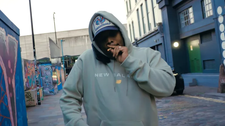 Styles P palący jointa na miejskiej ulicy, kadr z teledysku "Ride In / Ride Out"