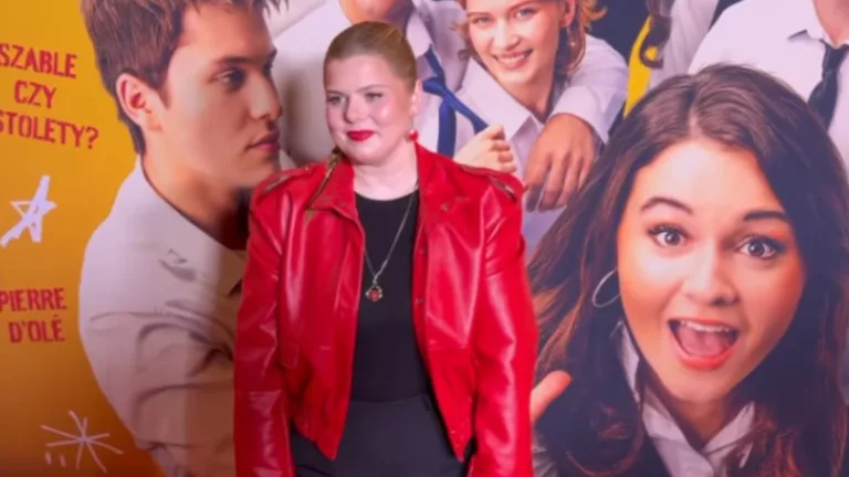 Ewa Makówka (Makowkamusic) w czerwonej skórzanej kurtce pozuje na ściance podczas premiery filmowej, na tle plakatu z młodymi aktorami.