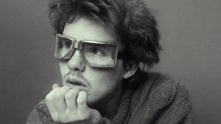 Cruz Beckham - For Your Love: czarno-białe zbliżenie artysty w dużych, kwadratowych okularach, patrzącego w bok w refleksyjnej pozie.