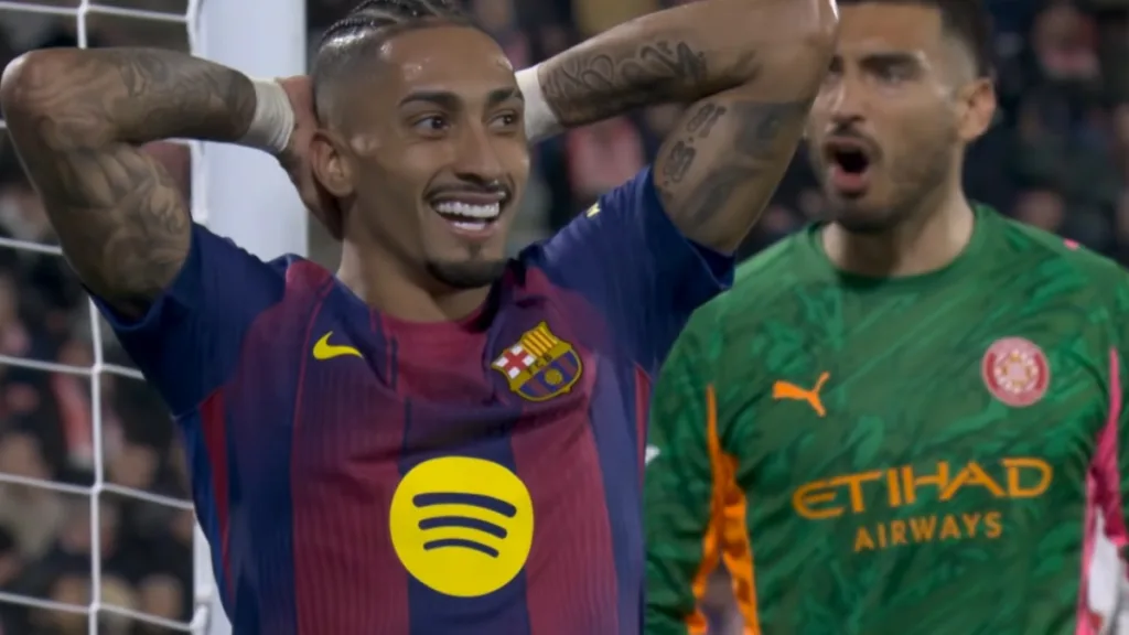 Raphinha z FC Barcelony z rękami za głową po niewykorzystanej okazji, w tle zaskoczony bramkarz Girony podczas derbów Katalonii.