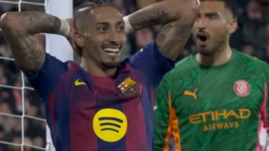 Raphinha z FC Barcelony z rękami za głową po niewykorzystanej okazji, w tle zaskoczony bramkarz Girony podczas derbów Katalonii.