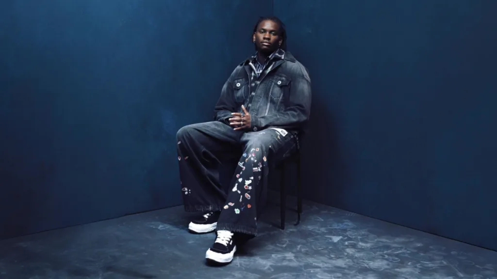 Victor Ray siedzący na krześle w ciemnym studiu, w jeansowym total looku, promujący mixtape I AM.