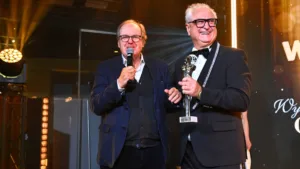 Wojciech Fibak i Mariusz Pujszo podczas Gali Osobowości i Sukcesy 2026 w Poznaniu, wręczenie statuetki na scenie wydarzenia.