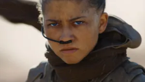 Chani na pustyni Arrakis w filmie Diuna: Część trzecia - zbliżenie bohaterki granej przez Zendaya w stroju Fremenów.