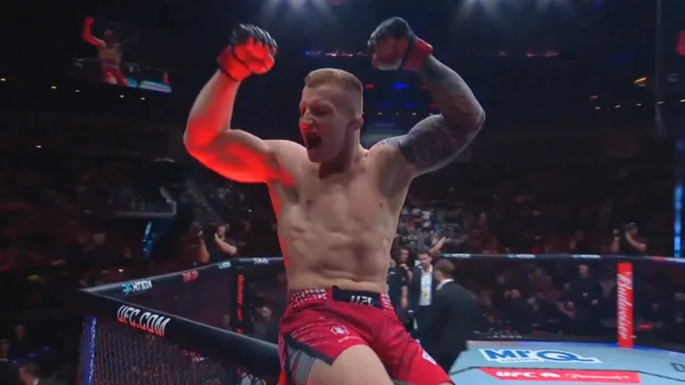 Iwo Baraniewski celebruje zwycięstwo po nokaucie na gali UFC w Londynie, stojąc w oktagonie z uniesionymi rękami