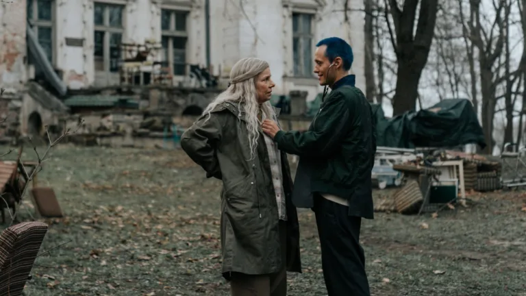 Scena z filmu "Czas, który nie nadszedł" - kobieta i mężczyzna rozmawiają przed zniszczonym budynkiem w jesiennej scenerii